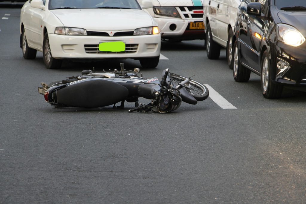 Motorcycle accident scene involving fallen bike in traffic is the best time to contact a motorcycle accidents attorney.  