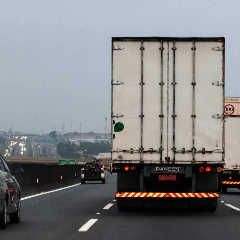 Large commercial truck driving on a multi-lane highway with surrounding traffic, one of the many causes of truck accidents